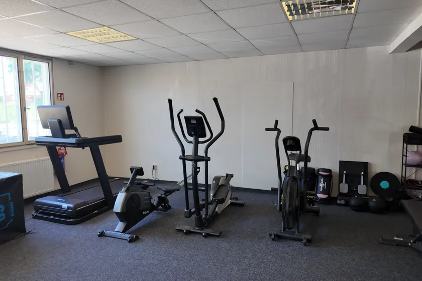 Běžecký pás, eliptický trenažér a rotoped v prostoru fitness